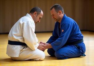 Judo coach instructing a student on the mat
